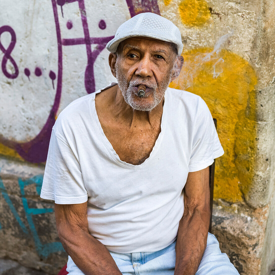 Portrait of a senior Cuban man smoking a cigar; Havana, Cuba