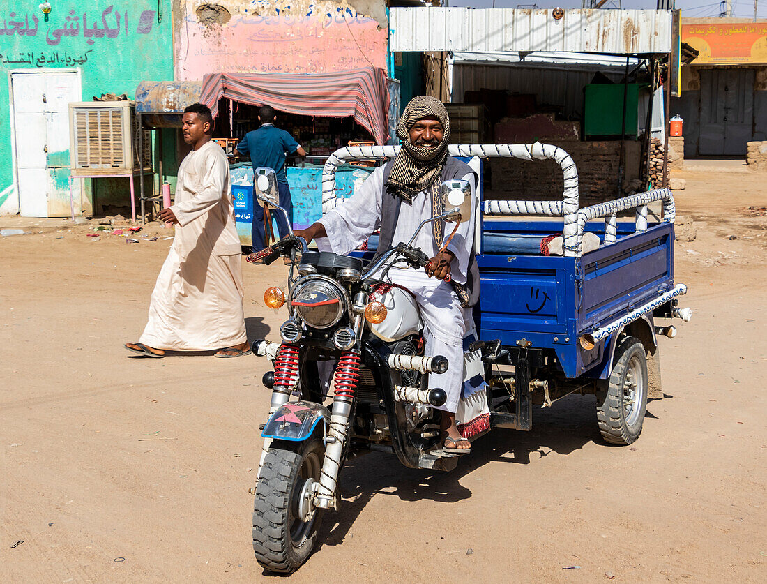 Sudanese, der ein motorisiertes Dreirad fährt; Abri, Nordstaat, Sudan