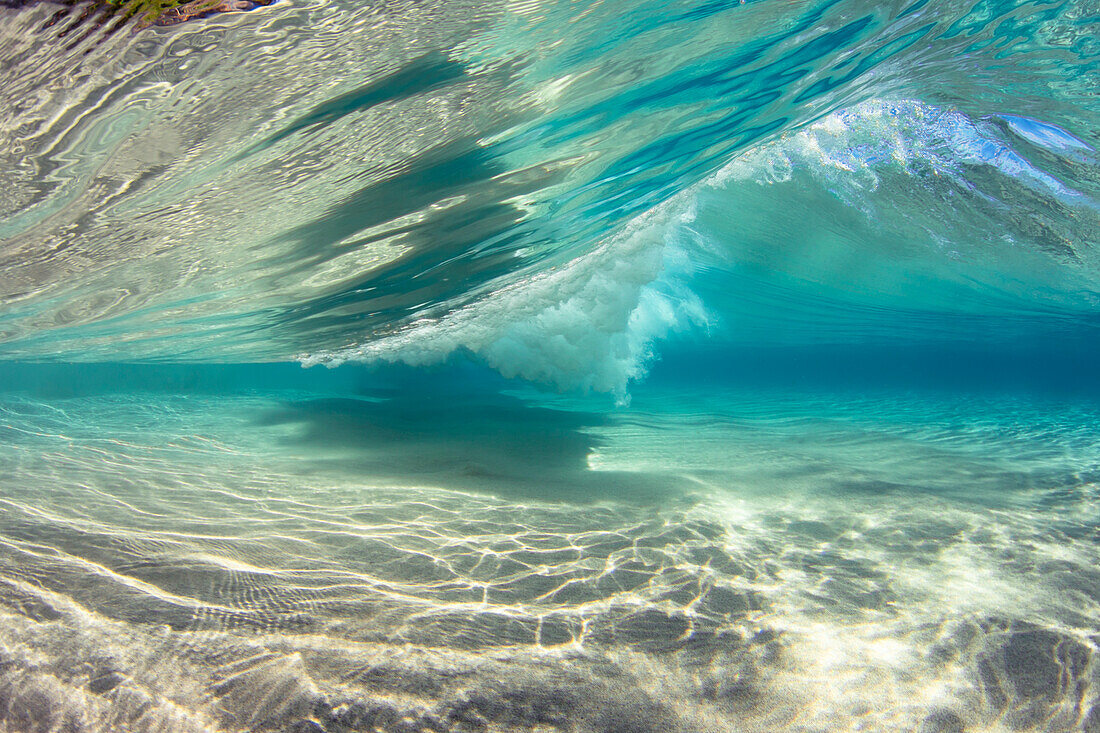 Surf crashes over a sandy bottom off the island of Maui; Maui, Hawaii, United States of America