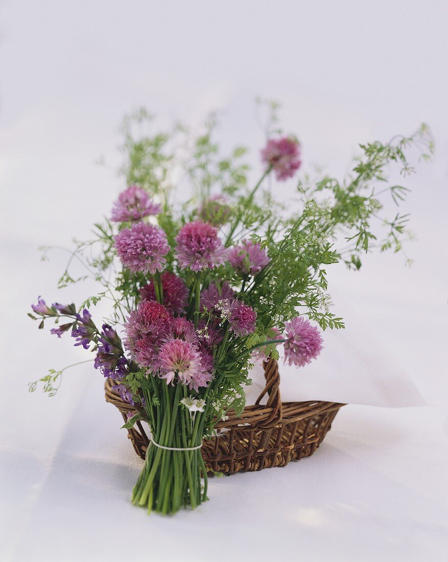 Bunch of flowering herbs in front of wicker basket