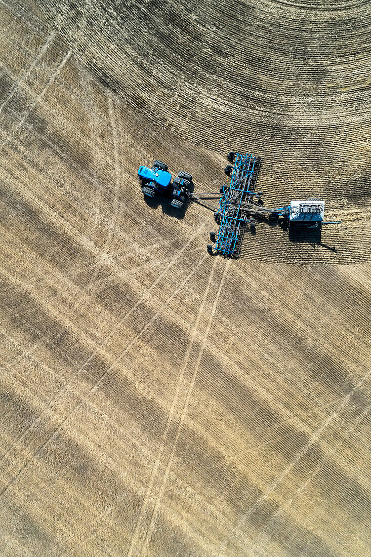 Luftaufnahme einer pneumatischen Sämaschine auf einem Feld in der Nähe von Beiseker; Alberta, Kanada