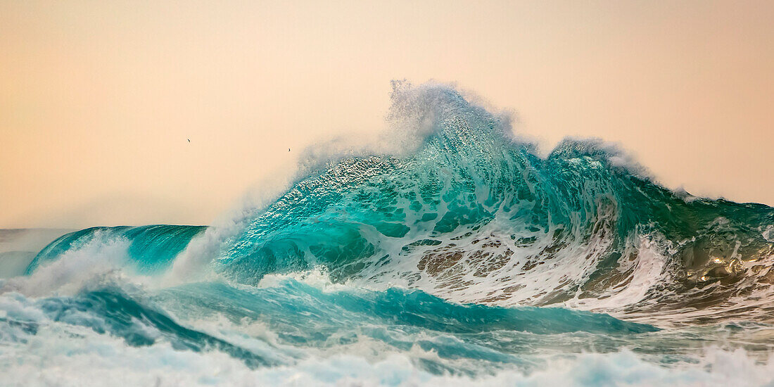 Wellen, die bei Sonnenuntergang an die Küste von Na Pali prallen; Kauai, Hawaii, Vereinigte Staaten von Amerika