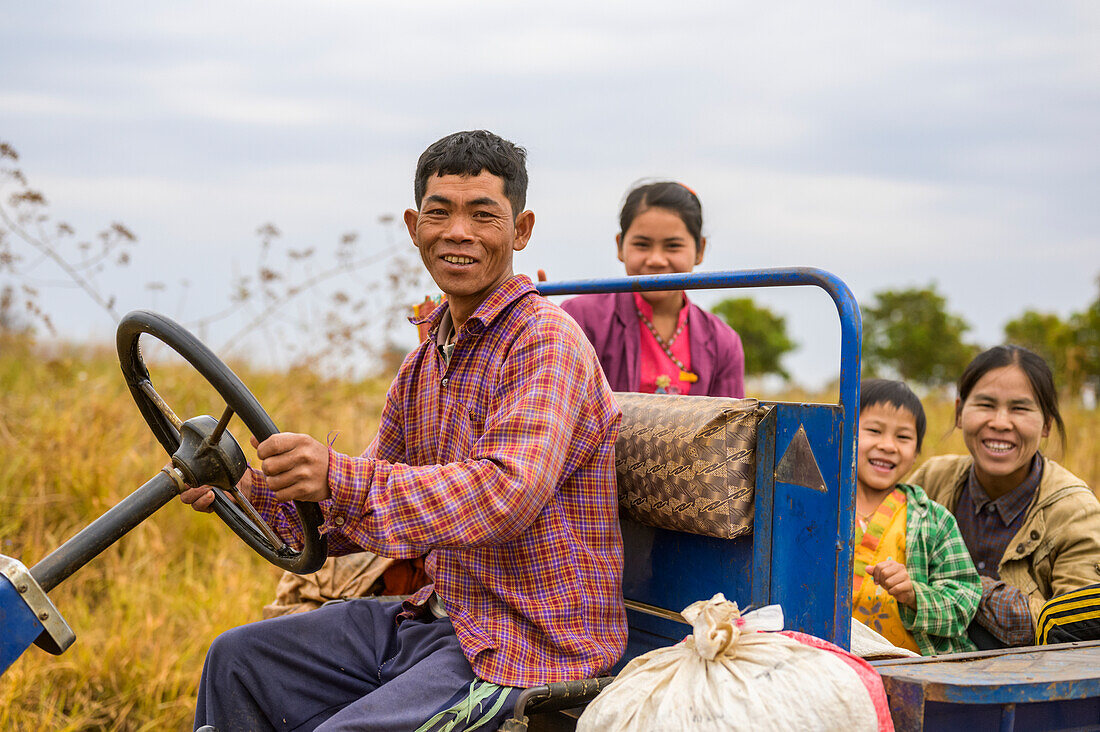 Familie fährt gemeinsam in einem Lastwagen durch landwirtschaftliche Felder; Taungyii, Shan-Staat, Myanmar