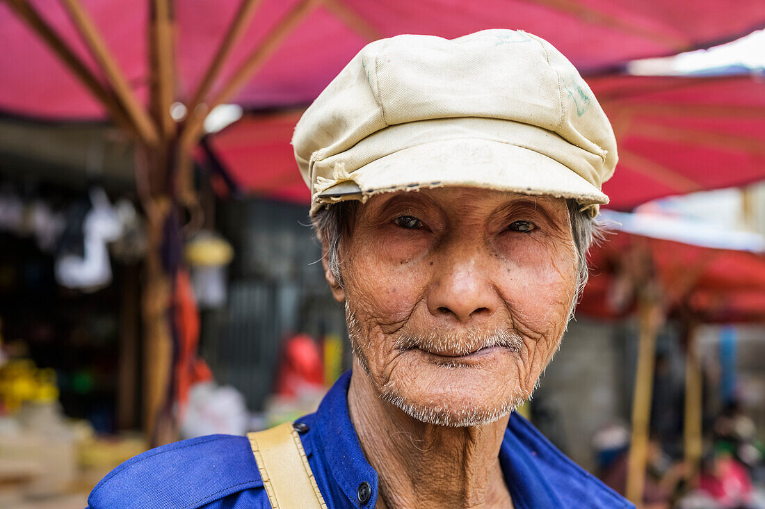 Porträt eines älteren Mannes, der auf dem Markt einen Hut trägt; Taungyii, Shan-Staat, Myanmar