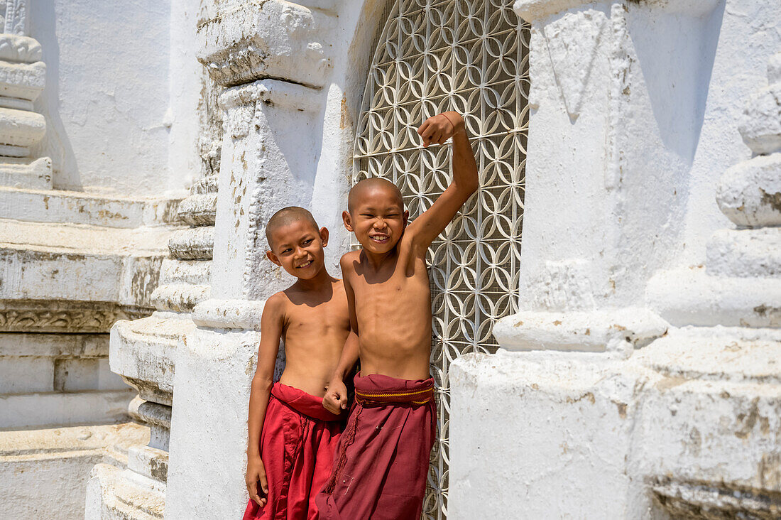 Junge Mönche in einem Tempel, die sich für die Kamera lächerlich machen; Bagan, Myanmar