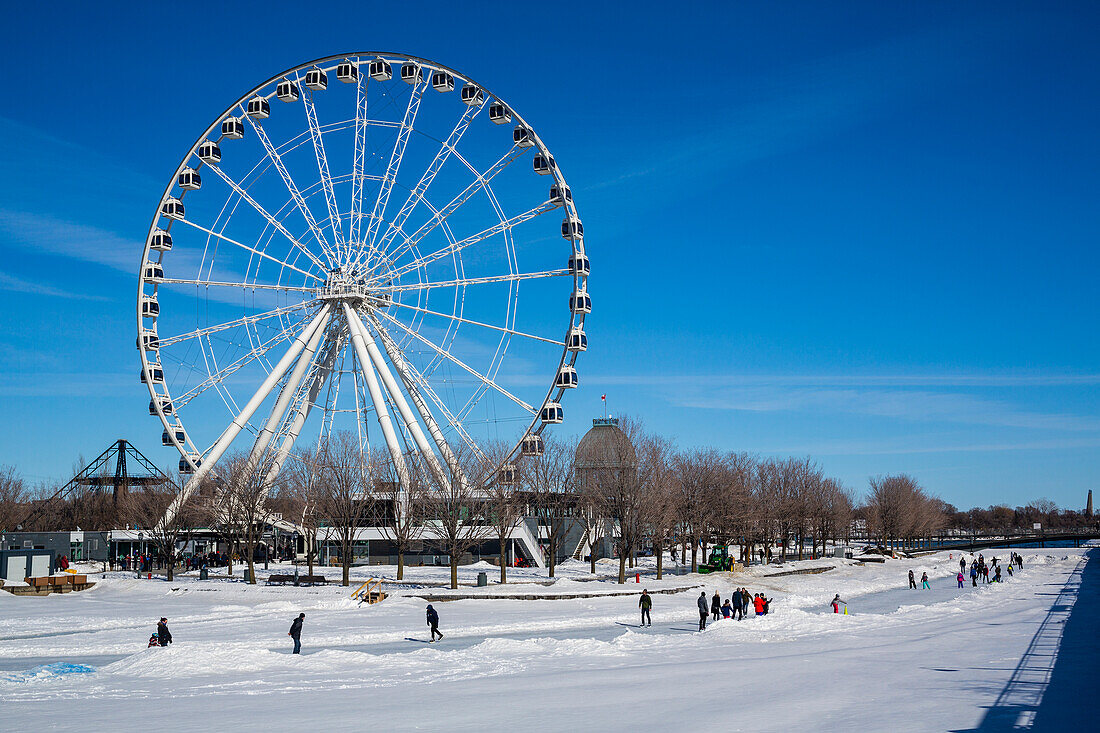 Das Riesenrad am alten Hafen im Winter mit Schlittschuhläufern auf dem Eis; Montreal, Québec, Kanada