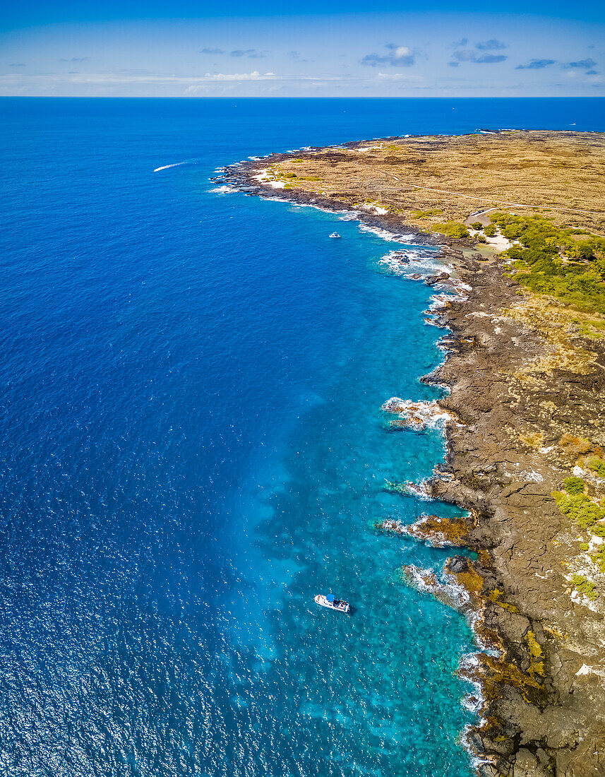 This aerial image includes a dive boat anchored at Pawai Bay and Keahuolu Point just north of Kailua-Kona town. The land pictured is part of the Lili?uokalani Land Trust for the benefit of Native Hawaiian children; Kailua, Island of Hawaii, Hawaii, United States of America