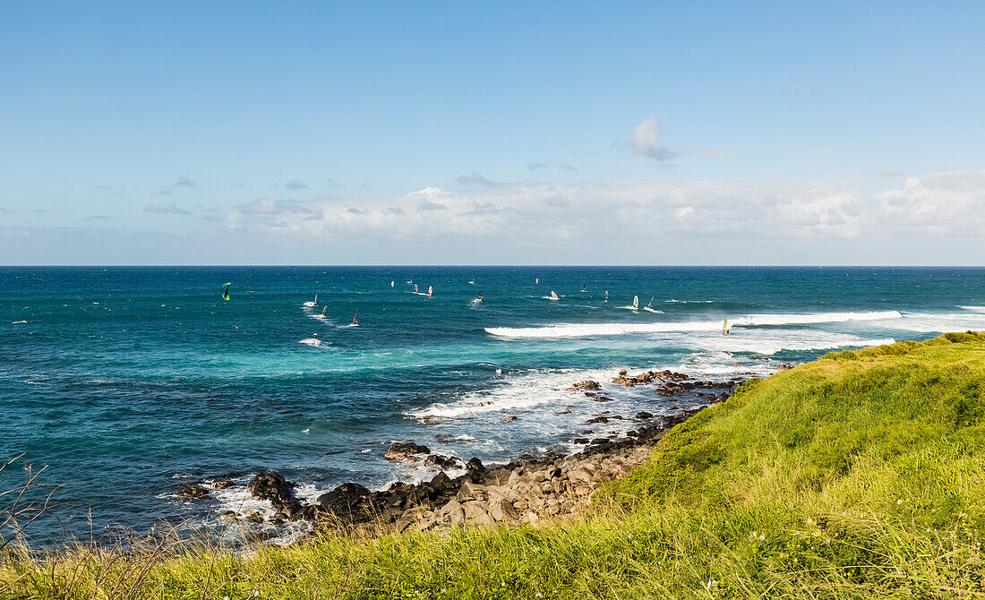 Windsurfer, die in der Brandung Wellen fangen, vom Ho'okipa Lookout bei Paia aus gesehen; Maui, Hawaii, Vereinigte Staaten von Amerika