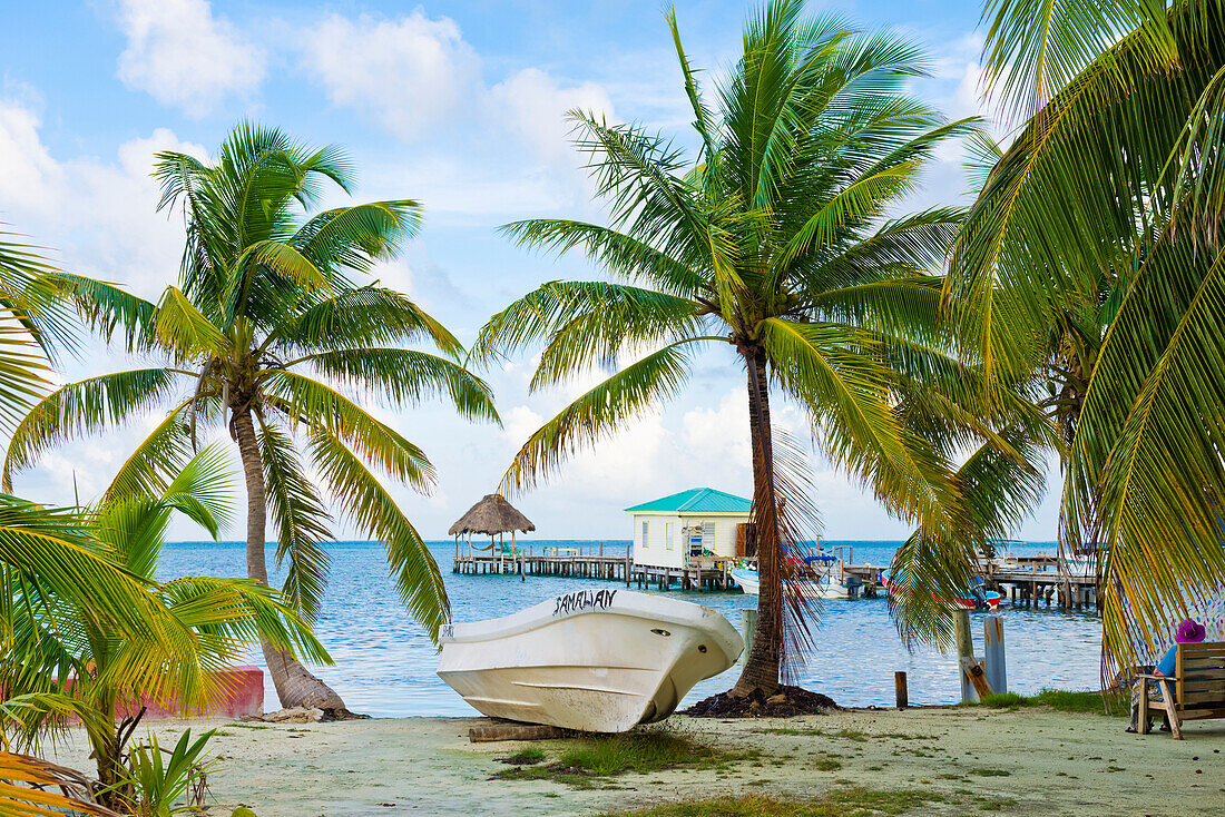 Tropischer Strand mit Pier und Bootshaus; Cay Caulker, Belize District, Belize