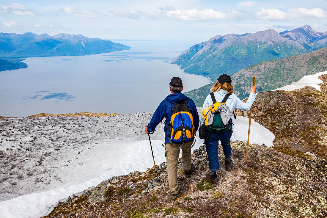 Wanderer in den Chugach-Bergen südlich von Anchorage, Süd-Zentral-Alaska. Sommer. Paar überblickt den Turnagain Arm und den Seward Highway; Alaska, Vereinigte Staaten von Amerika