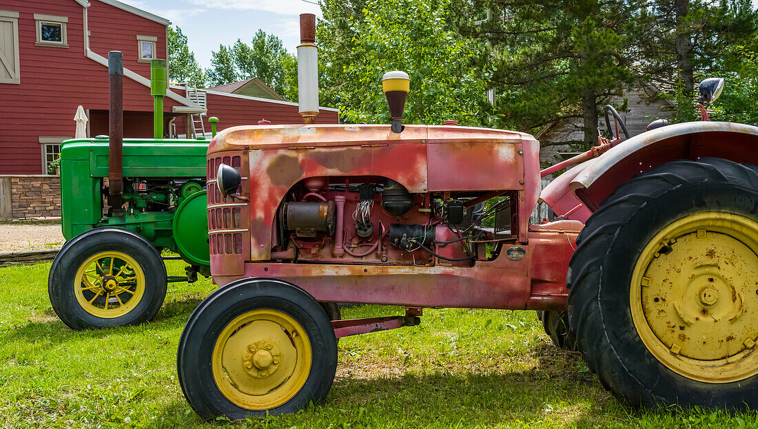Tractors parked on grass in a farmyard, Wheatland County; Rosebud, Alberta, Canada