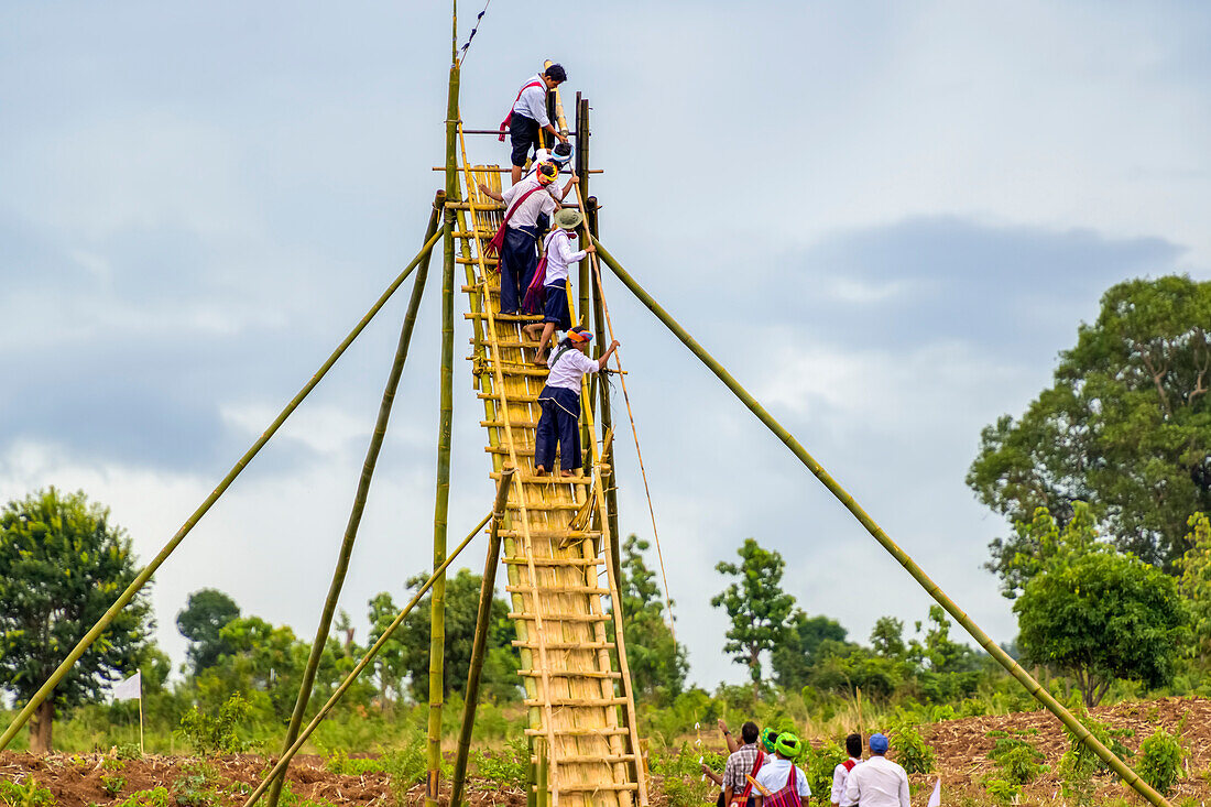 Men climbing a structure with a rocket during a festival, Pa'O Tribe; Yawngshwe, Shan State, Myanmar