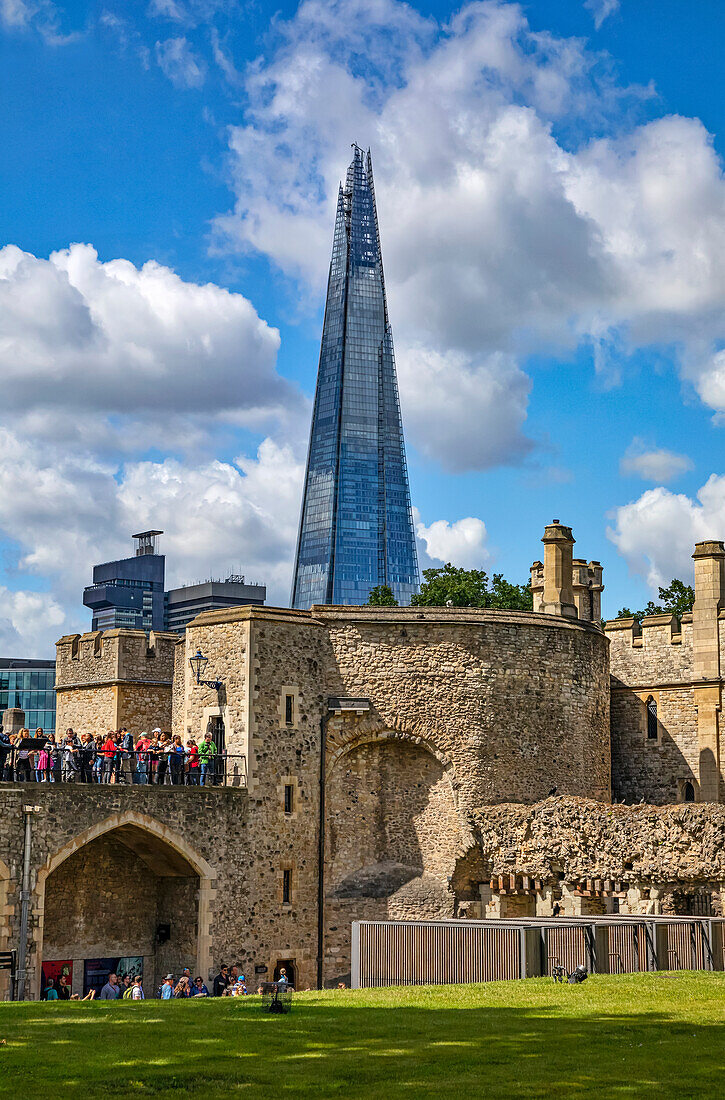 Tourists at the Tower of London with the Shard commerical skyscraper in the background; London, England