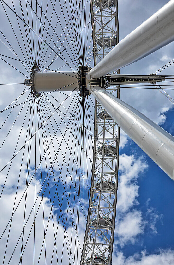 Blick von direkt unter den Seilen und Gondeln des London Eye mit blauem Himmel und Wolken im Hintergrund; London, England