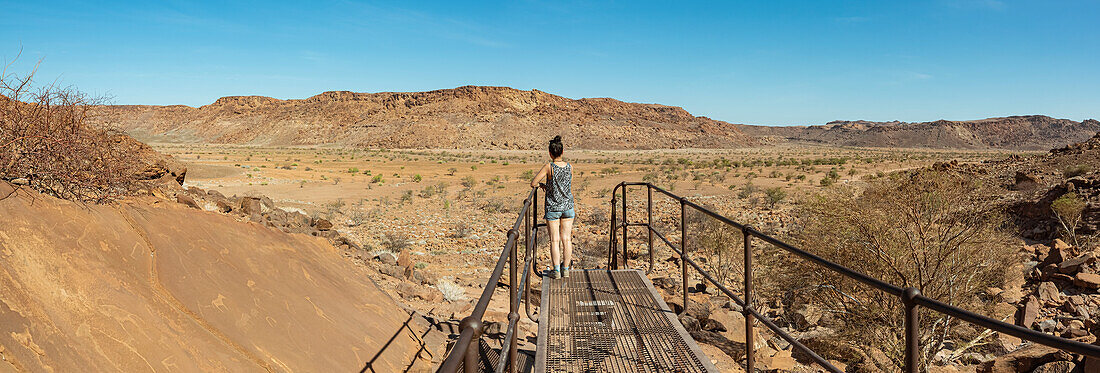 Woman standing on walkway at  Twyfelfontein, an ancient rock engravings site, Damaraland; Kunene Region, Namibia