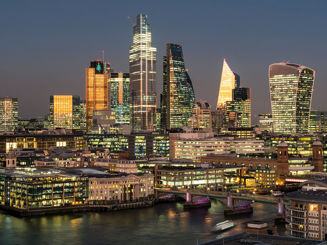 Stadtbild und Skyline von London in der Abenddämmerung mit 20 Fenchurch, 22 Bishopsgate und verschiedenen anderen Wolkenkratzern sowie der Themse im Vordergrund; London, England