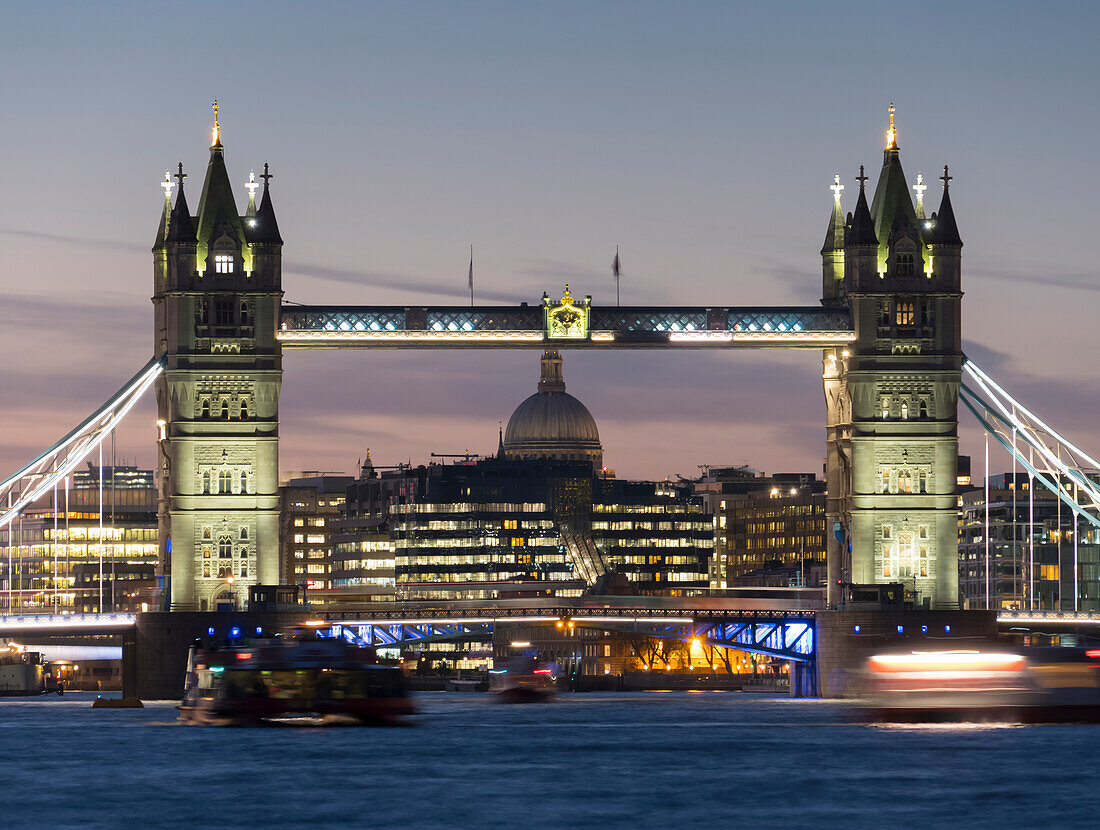 Tower Bridge und St. Paul's Cathedral mit der Themse im Vordergrund in der Abenddämmerung; London, England