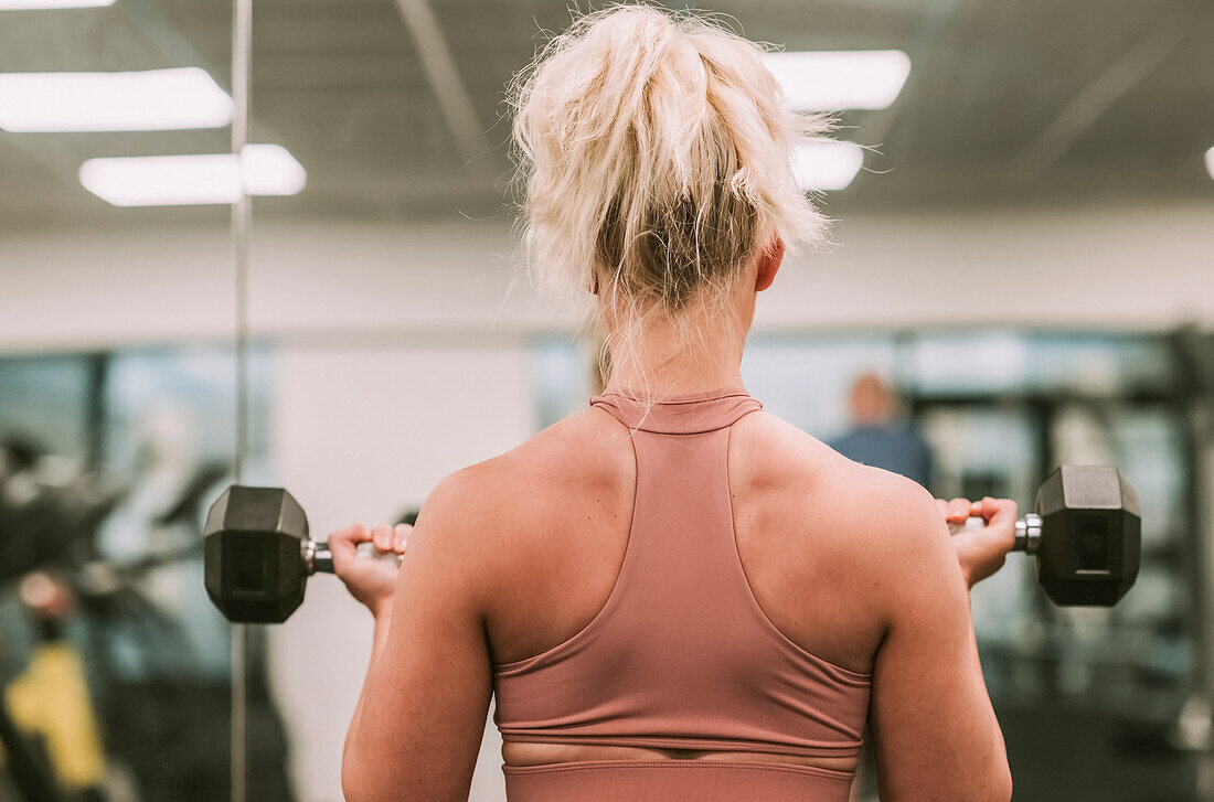 Woman working out with weights; Wellington, New Zealand