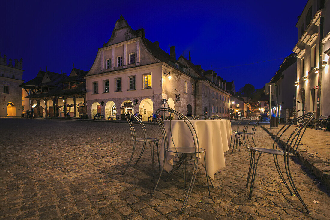 Empty restaurant table in a Polish old town square at night; Kazimierz Dolny, Lublin Voivodeship, Poland