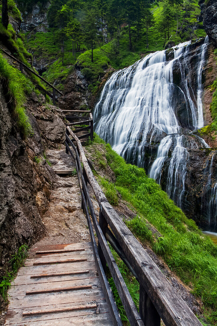 A wooden walkway leading to the Wasserlochklamm waterfall cascades in the Austrian Alps, long exposure; Landl, Austria