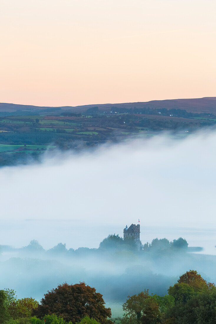 Castlebawn am Ufer des Lough Derg, umgeben von Nebel und Dunst, bei Sonnenaufgang im Herbst; Ogonnelloe, County Clare, Irland