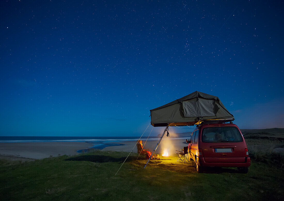 Car with roof tent camping by Falcarragh Beach at night; County Donegal, Ireland