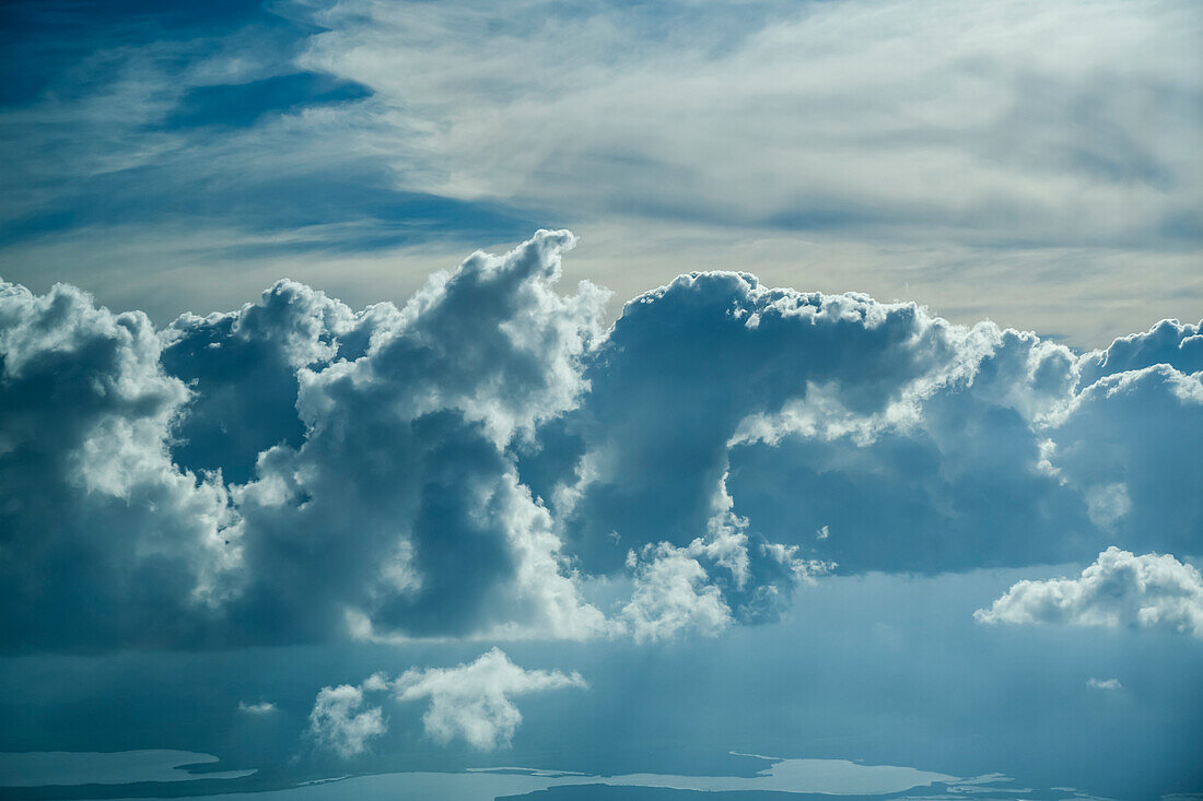 Clouds glowing with sunlight in the sky and lakes on the ground below; Belize