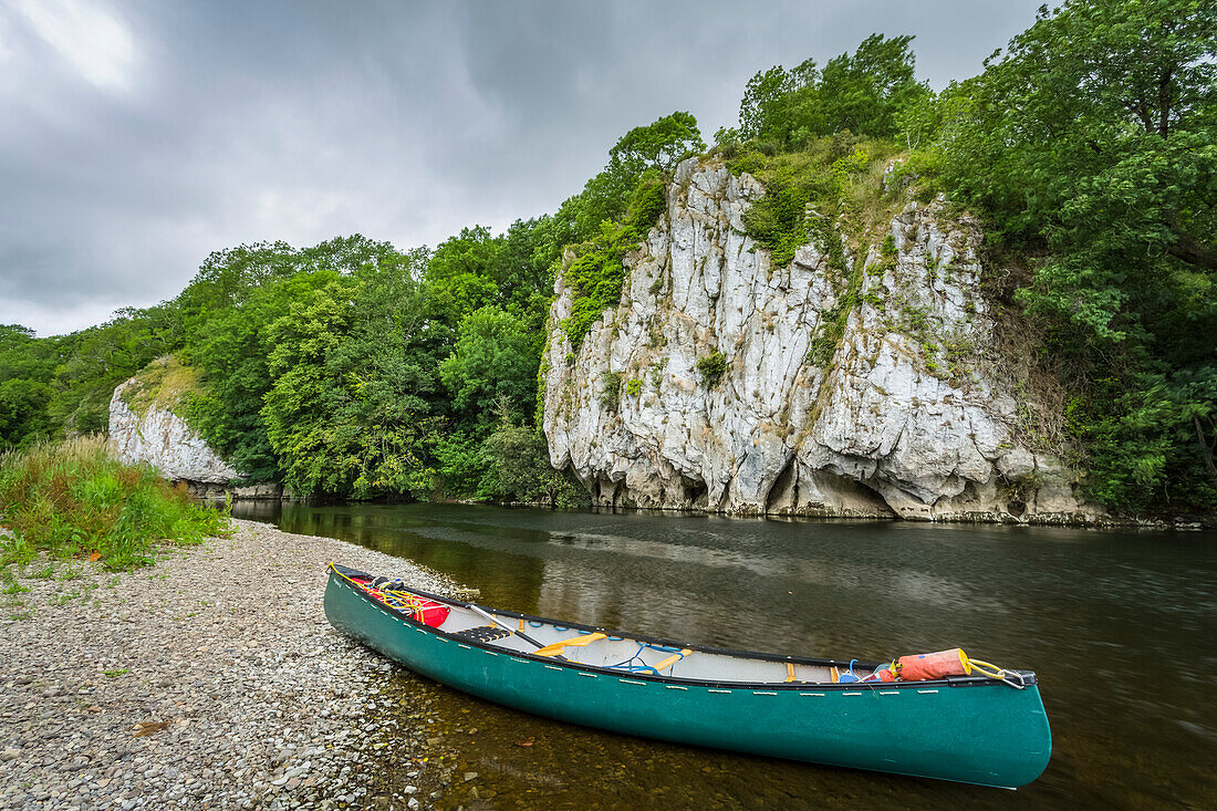 Ein grünes Kanu am Ufer des Blackwater River in Cork mit weißen Klippen am gegenüberliegenden Ufer im Sommer; Killavullen, Grafschaft Cork, Irland