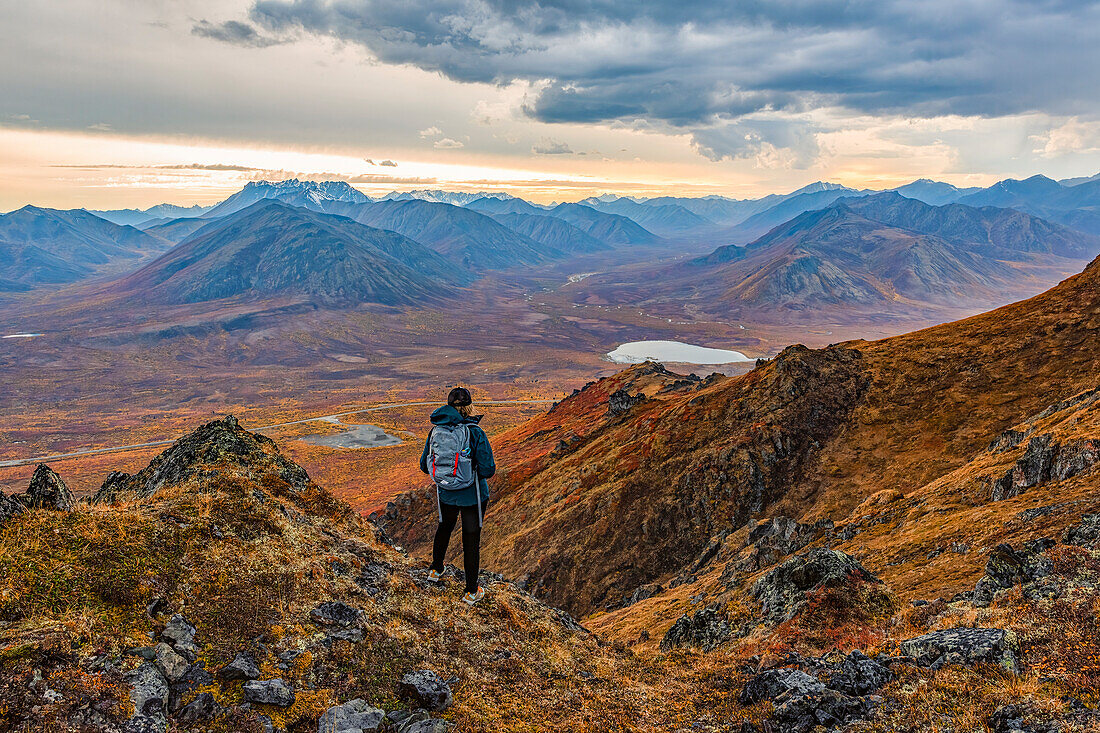 Frau erkundet die Berge entlang des Dempster Highway im Herbst im Herbst; Yukon, Kanada