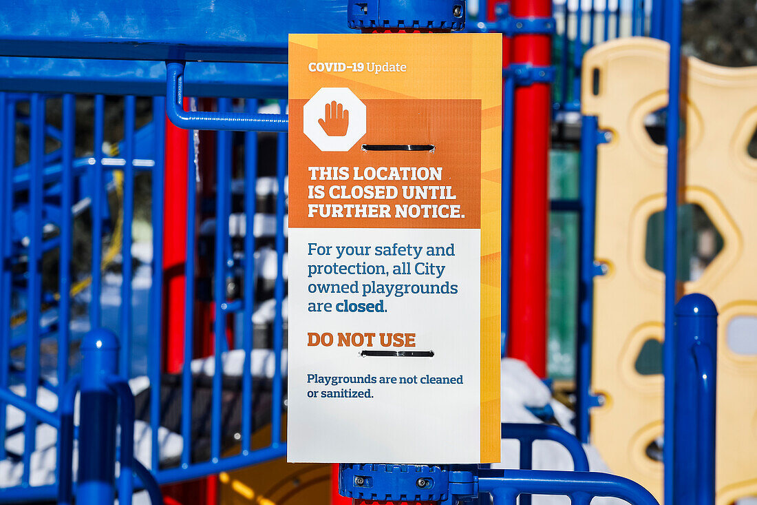 Ein Schild an einem Spielplatz, der während der COVID-19-Weltpandemie mit Absperrband abgesperrt wurde; Edmonton, Alberta, Kanada