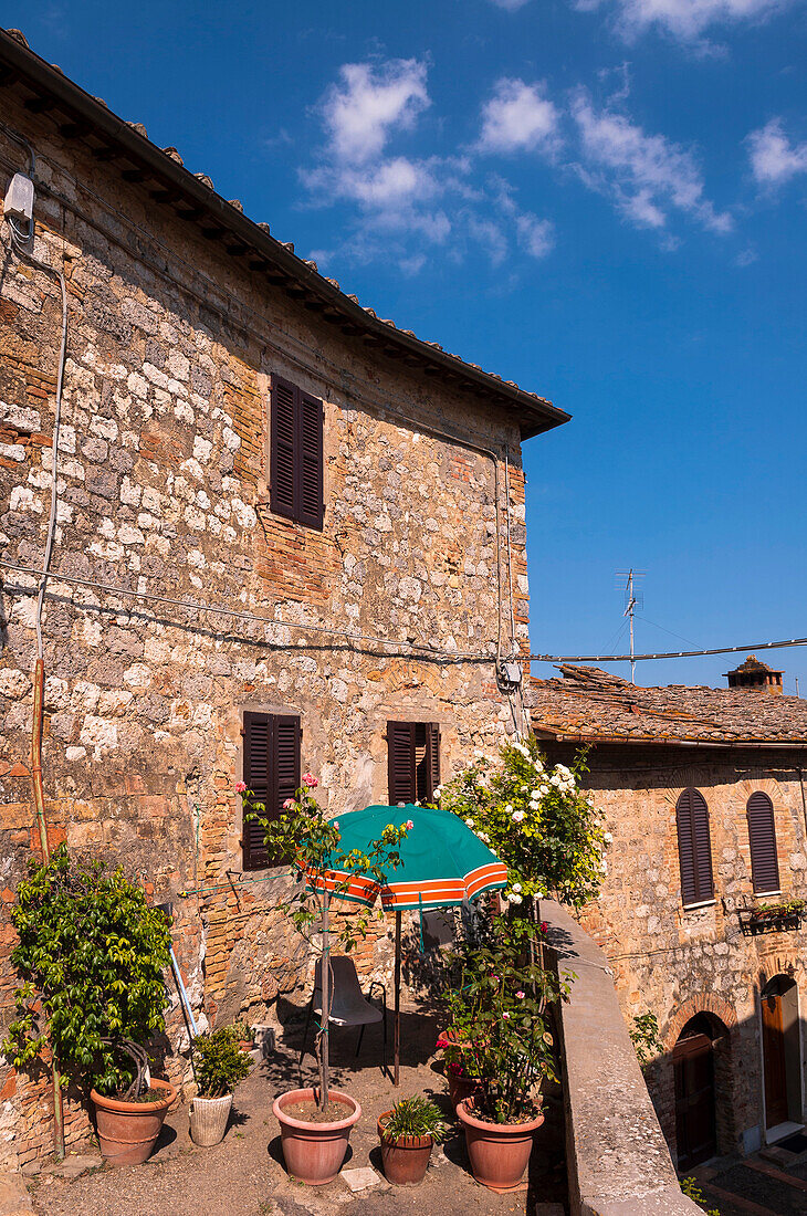 View of building with balcony garden, San Gimignano, Province of Siena, Tuscany, Italy