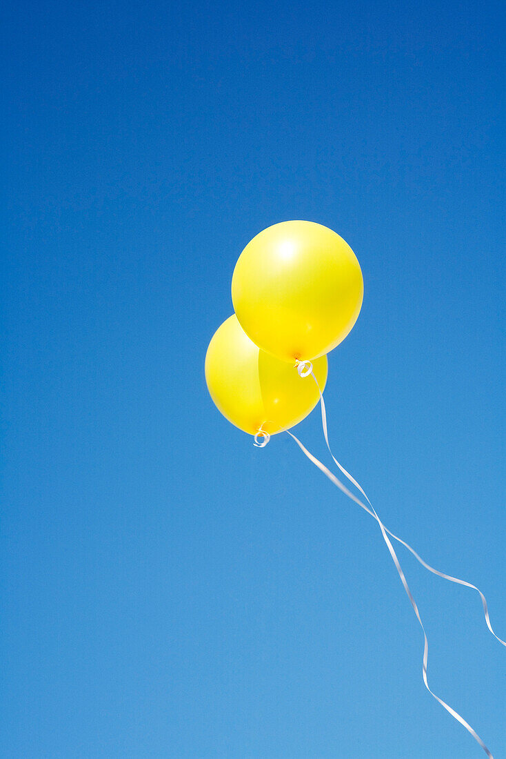 Zwei gelbe Ballons im Himmel
