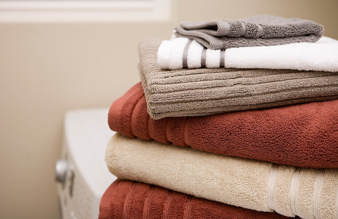 Stapel sauberer Handtücher auf der Waschmaschine und dem Trockner