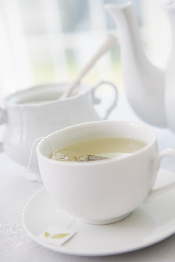 Teetasse aus weißem Porzellan mit Untertasse, Zuckerdose und Teekanne, Atelieraufnahme