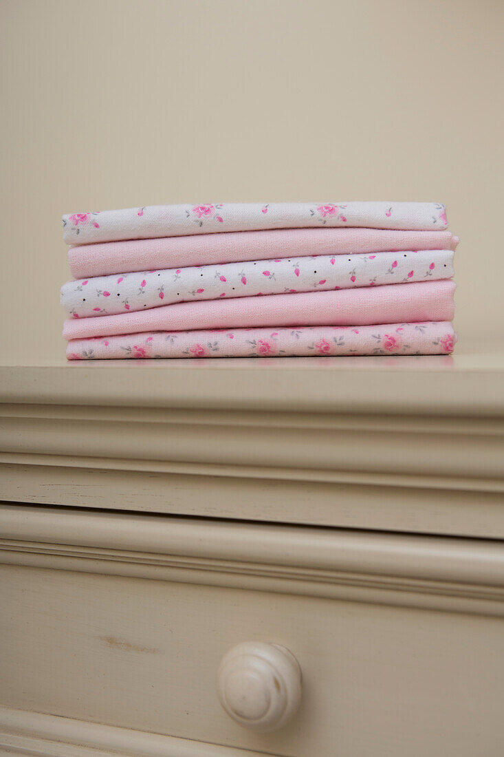 Stack of Pink Baby Blankets on Dresser in Nursery