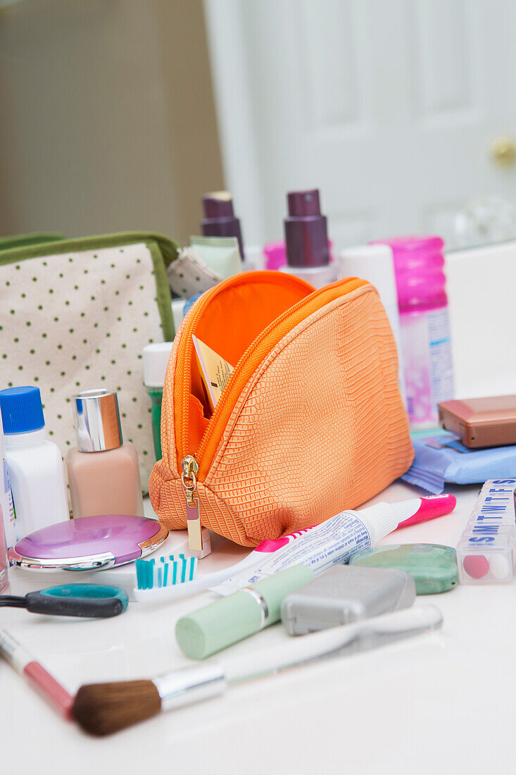 Damentoilettenreisetasche auf dem Badezimmertresen, gefüllt mit Körperpflegeprodukten