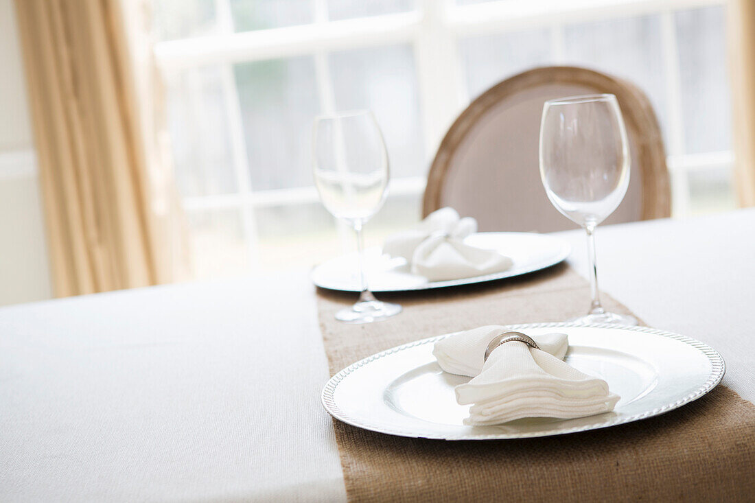 Simple and elegant place setting for two with plate charger and napkin