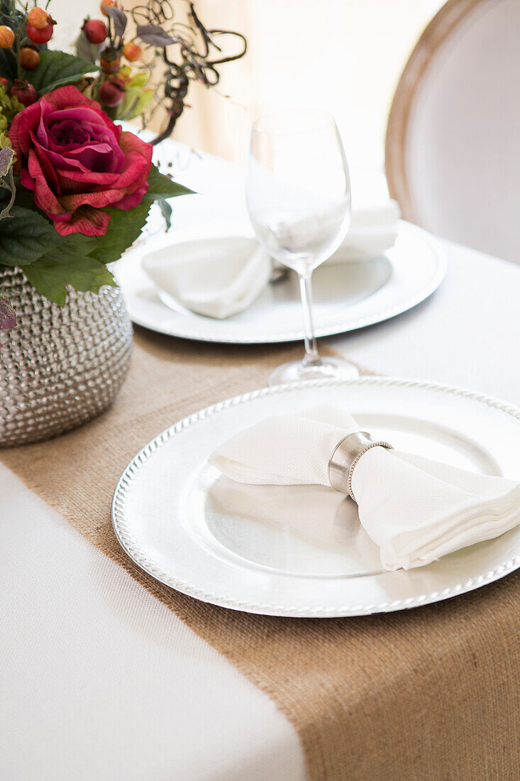Elegant table setting at wedding event with plate charger and napkin