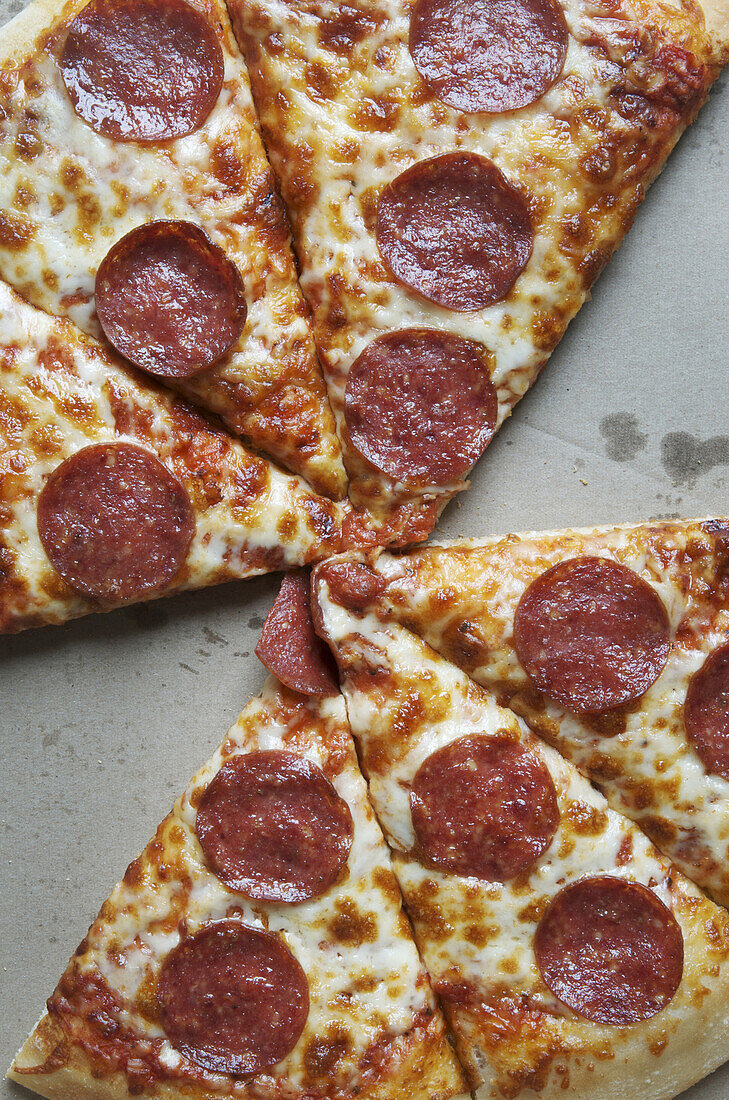 Draufsicht auf eine geschnittene Peperoni-Pizza in einer Schachtel