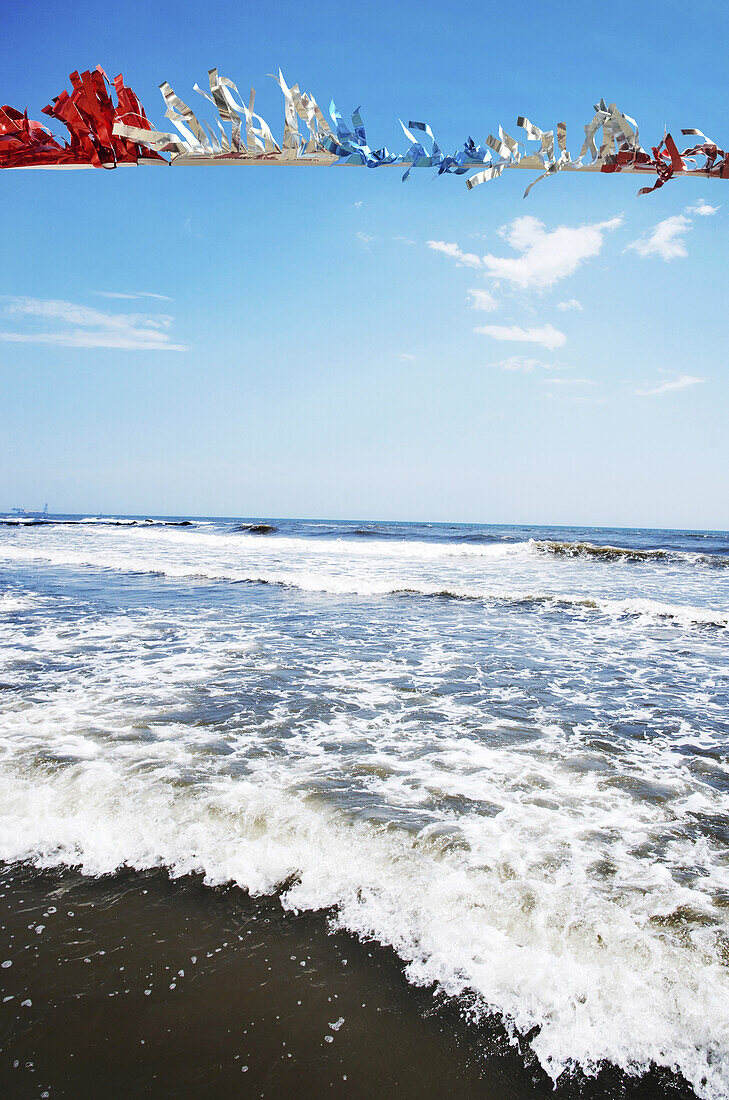 Red, White and Blue Streamers Blowing in Breeze at Beach, Atlantic Ocean