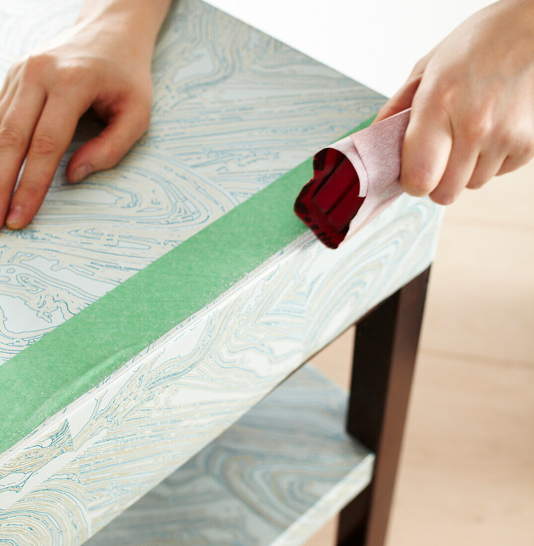 Close-up of Woman's Hands Sanding Table in Studio