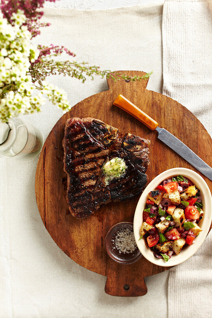 Draufsicht auf Steak und Salat auf Schneidebrett, Studioaufnahme