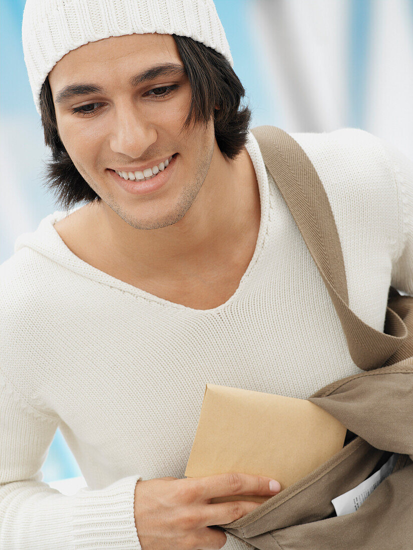 Man Putting Envelope in Bag