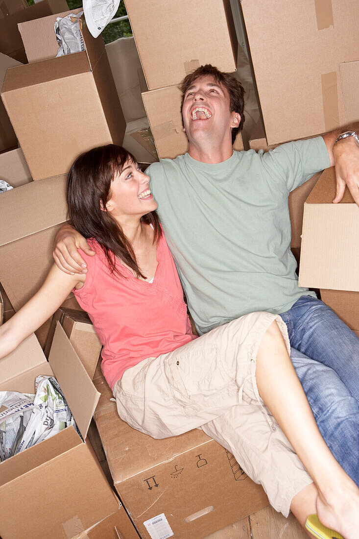 Couple Sitting Amongst Moving Boxes