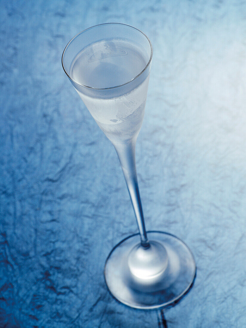 Glas Aquavit auf blauem Hintergrund, Studioaufnahme