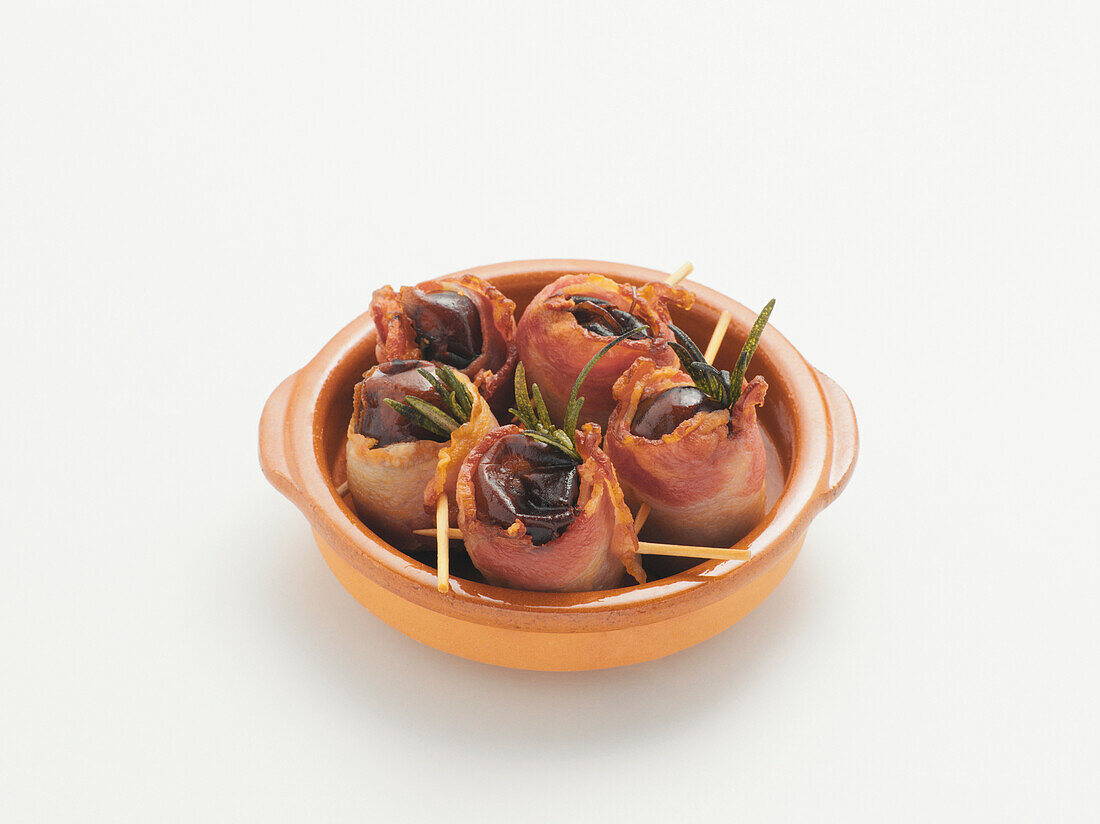 Dates Wrapped with Bacon on White Background, Studio Shot