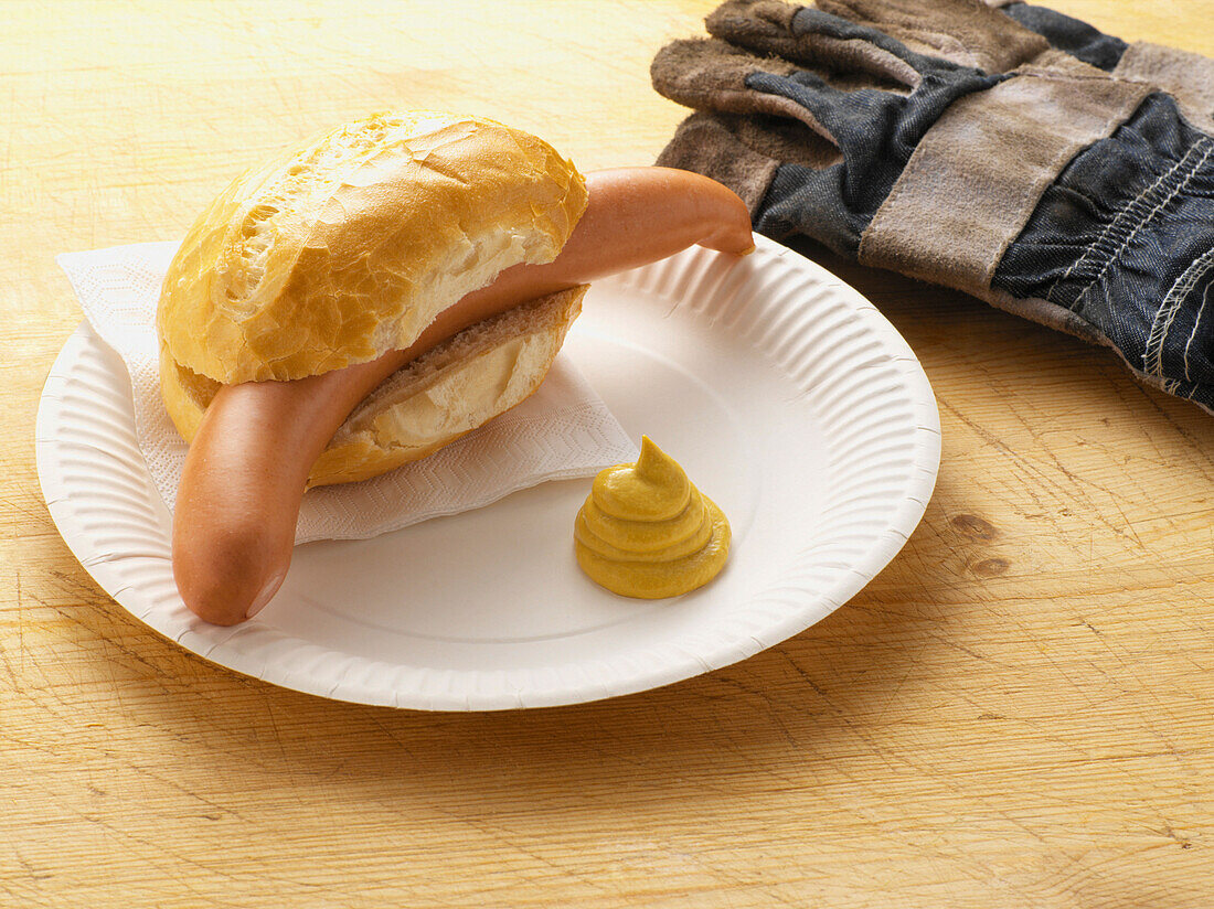 Vienna Sausage in Bun with Mustard on Paper Plate