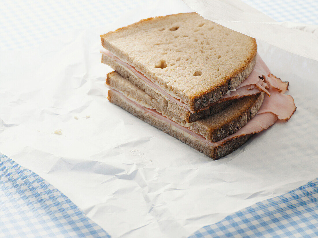Nahaufnahme von Schinken-Sandwich auf Pergamentpapier
