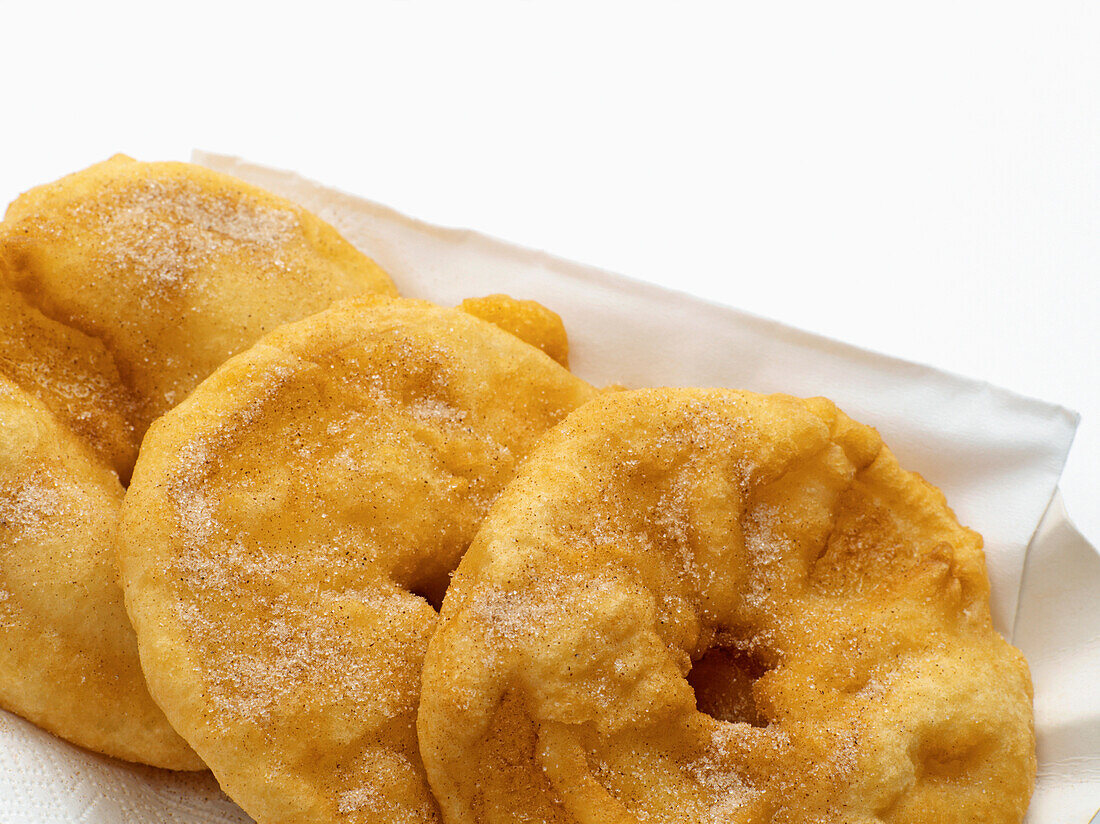 Close-up of baked apple slices on paper plate, white background, studio shot