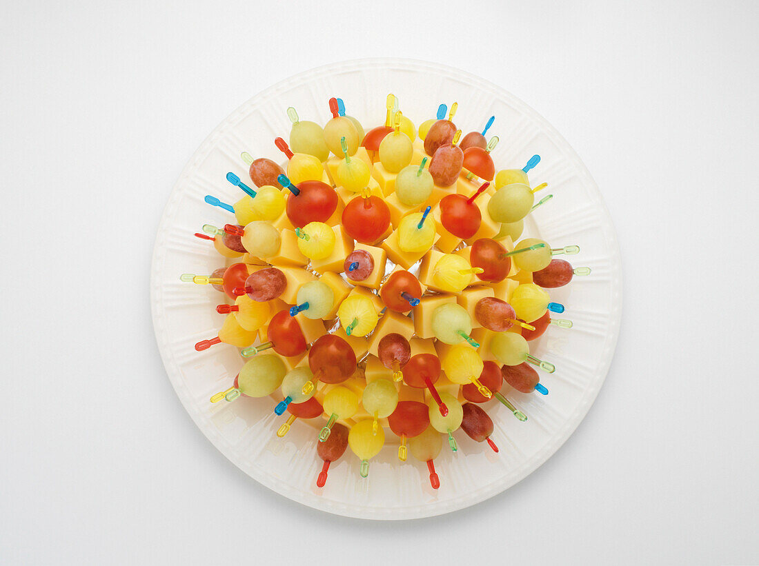 Appetizer Picks mit Käse und Obst in Kugelform auf Pappteller, weißer Hintergrund, Studioaufnahme